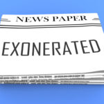 Newspaper with EXONERATED headline on the front page.