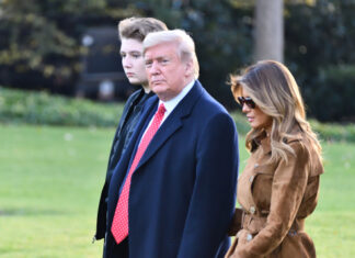 Donald Trump with wife Melania and son Barron walking together.