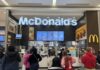 People standing in line at McDonald's inside mall.