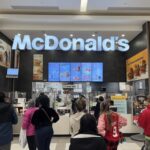 People standing in line at McDonald's inside mall.