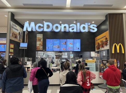 People standing in line at McDonald's inside mall.