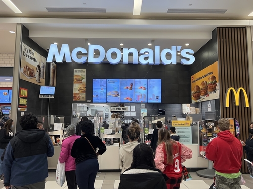 People standing in line at McDonald's inside mall.