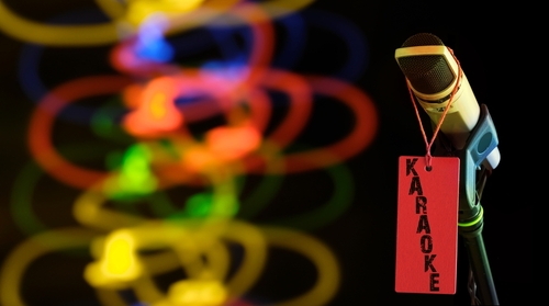 Microphone with "Karaoke" tag, colorful lights in background.