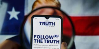 Phone displaying Truth Social app over American flag background.