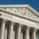 Supreme Court building facade with American flag.