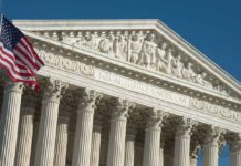 Supreme Court building facade with American flag.