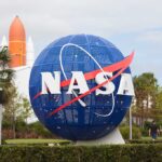 NASA globe sculpture with rocket in background.