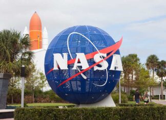 NASA globe sculpture with rocket in background.