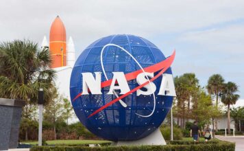 NASA globe sculpture with rocket in background.