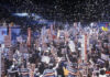 Crowd holding Clinton signs at a political rally.