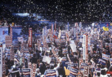 Crowd holding Clinton signs at a political rally.