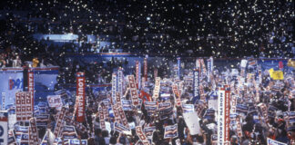 Crowd holding Clinton signs at a political rally.