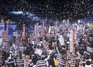 Crowd holding Clinton signs at a political rally.