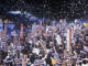 Crowd holding Clinton signs at a political rally.