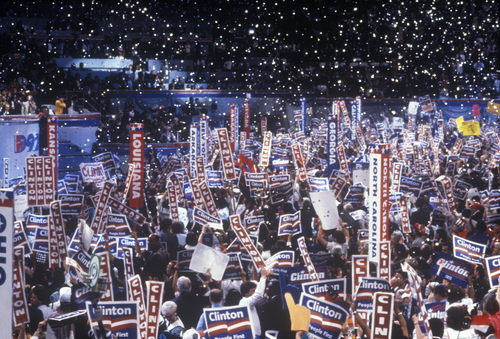 Crowd holding Clinton signs at a political rally.