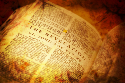 Open Bible showing the Book of Revelation text.