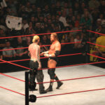 Wrestlers facing off in a ring at a match.