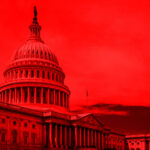 United States Capitol building under red-hued sky.