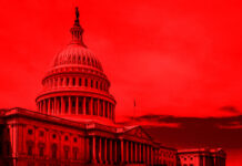 United States Capitol building under red-hued sky.