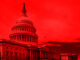 United States Capitol building under red-hued sky.