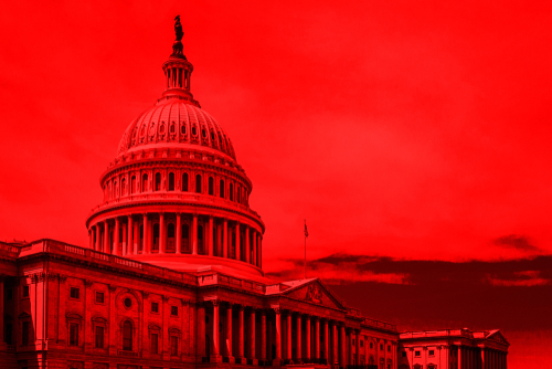 United States Capitol building under red-hued sky.