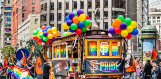 San Francisco trolley adorned with pride decorations and balloons.