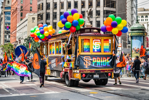 San Francisco trolley adorned with pride decorations and balloons.