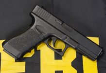 Black handgun on a yellow and black background.