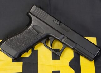 Black handgun on a yellow and black background.