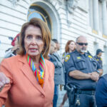 Nancy Pelosi speaking outside a government building.