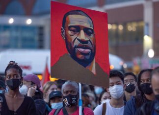 People protesting with a painting of a man.