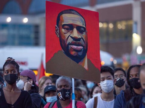 People protesting with a painting of a man.