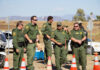 Uniformed officers standing outdoors next to traffic cones.