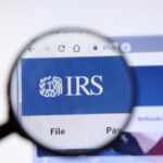 Magnifying glass focusing on IRS logo on a website.