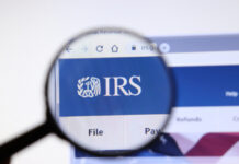 Magnifying glass focusing on IRS logo on a website.