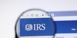 Magnifying glass focusing on IRS logo on a website.