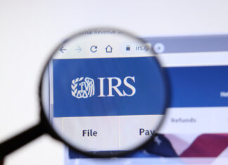 Magnifying glass focusing on IRS logo on a website.