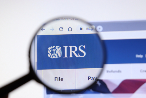 Magnifying glass focusing on IRS logo on a website.