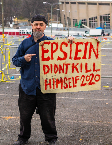 Man holding Epstein didn't kill himself 2020 sign.