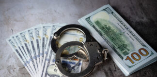 Handcuffs with one hundred dollar bills.