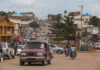 Busy street in an urban area with cars and motorcycles.