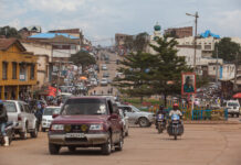 Busy street in an urban area with cars and motorcycles.