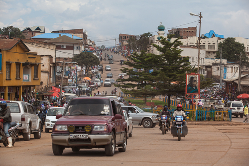 Busy street in an urban area with cars and motorcycles.