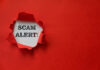 Torn red paper revealing scam Alert!