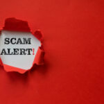 Torn red paper revealing scam Alert!