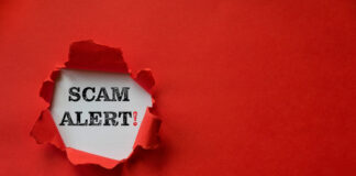 Torn red paper revealing scam Alert!