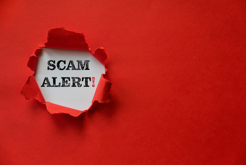 Torn red paper revealing scam Alert!