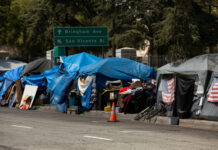 Tents and shelters line a street in a city.