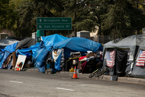 Tents and shelters line a street in a city.