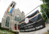 Church with rainbow flag and welcoming sign for LGBTQ+.